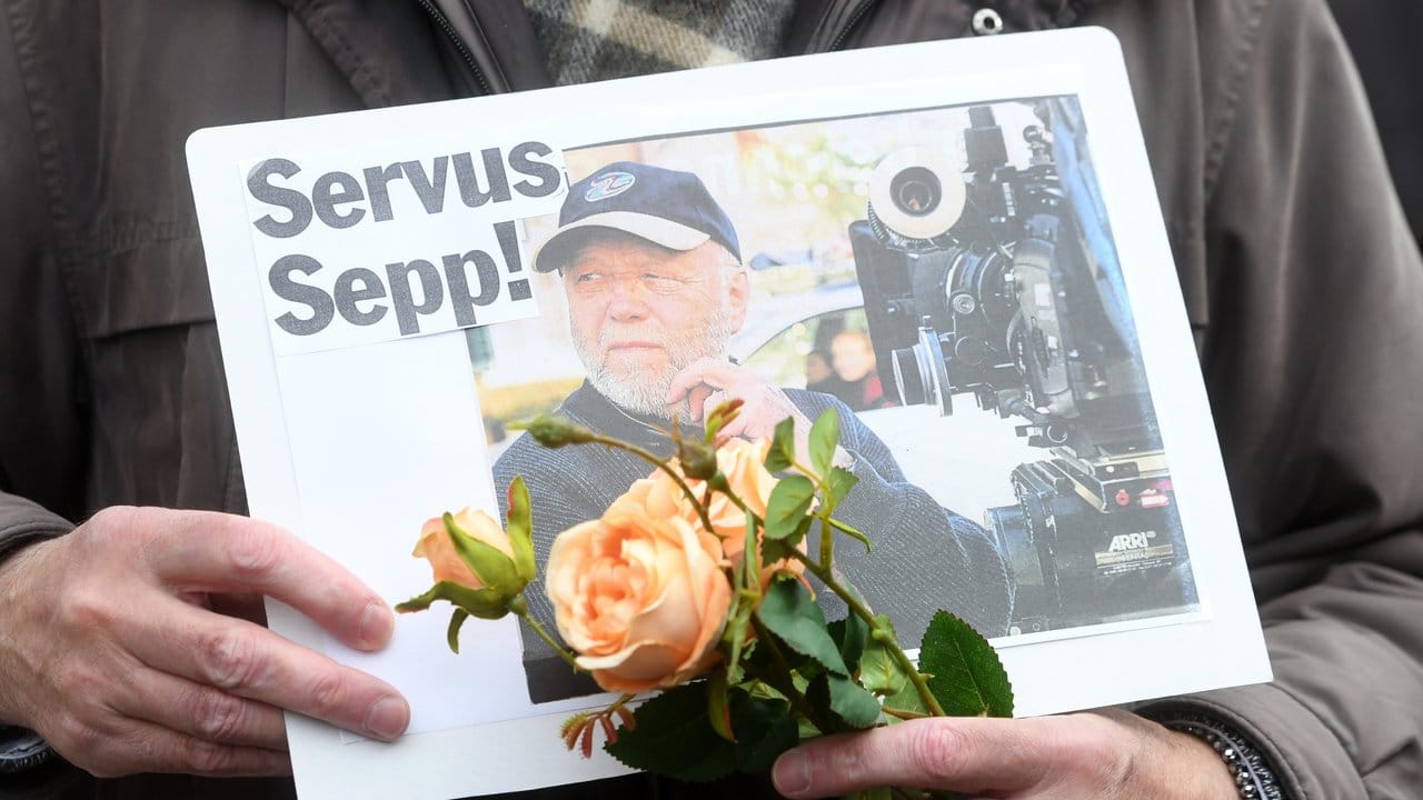 Ein Fan mit Blumen und einem letzten Gruß: "Servus Sepp!".