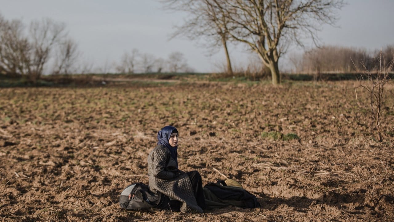 Eine Frau sitzt neben ihren Habseligkeiten, während sie auf die Öffnung des Grenzübergangs Pazarkule an der türkisch-griechischen Grenze wartet.
