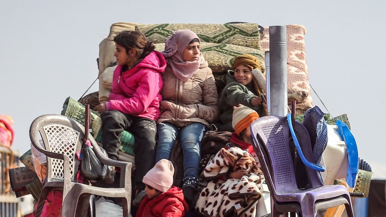 Flucht aus Idlib: Kinder sitzen auf der Ladefläche eines Kleintransporters auf den Habseligkeiten ihrer Familie.