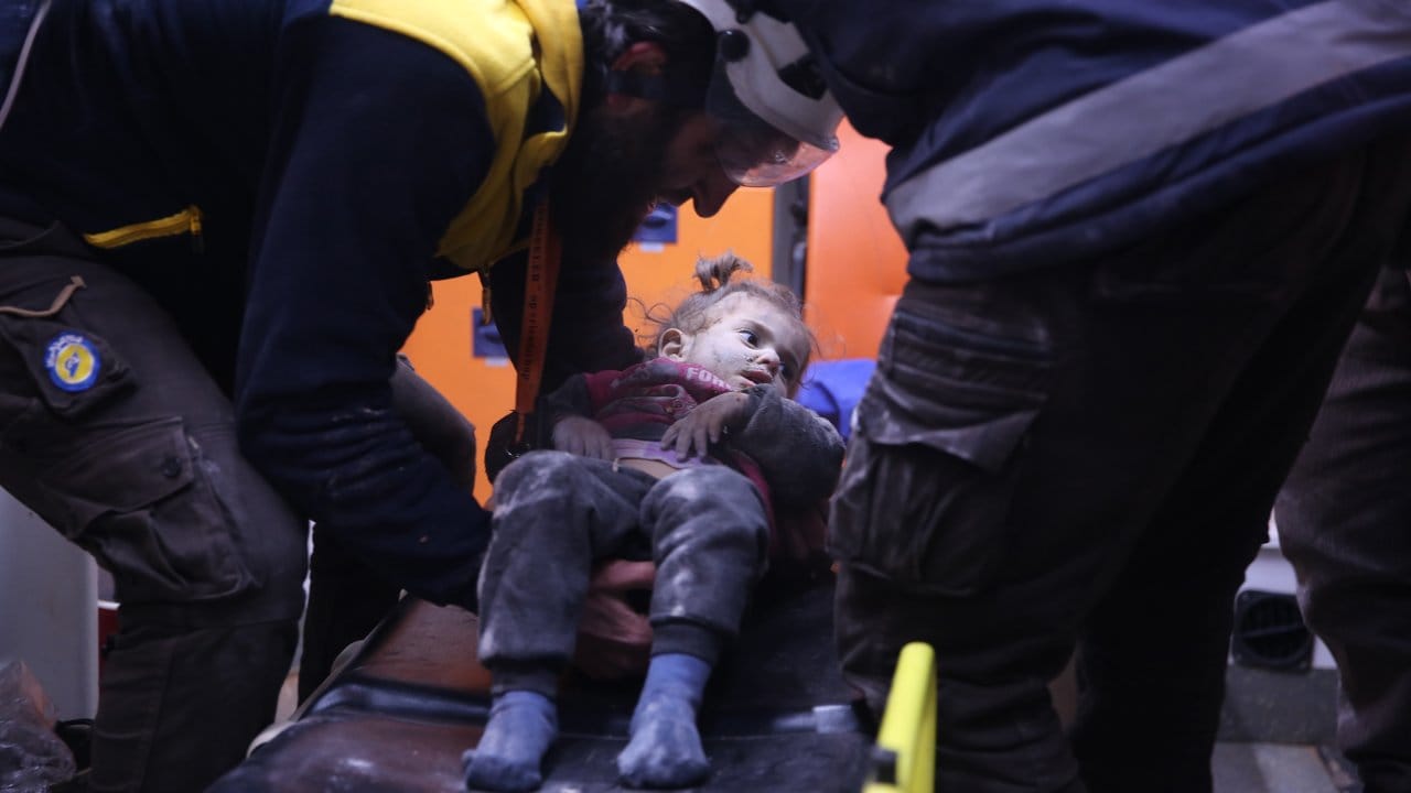 Rettungskräfte versorgen nach einem Luftangriff ein verwundetes syrisches Mädchen.