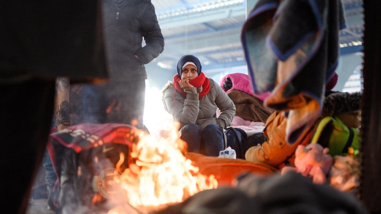 Eine Frau aus Syrien sitzt an einem Lagerfeuer nahe der türkisch-griechischen Grenze.