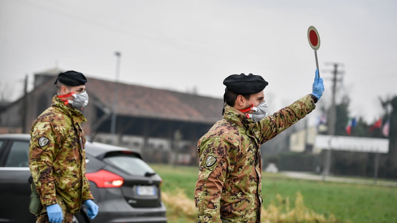Ein Soldat mit Atemschutzmaske prüft die Ein- und Ausreise in Italien.