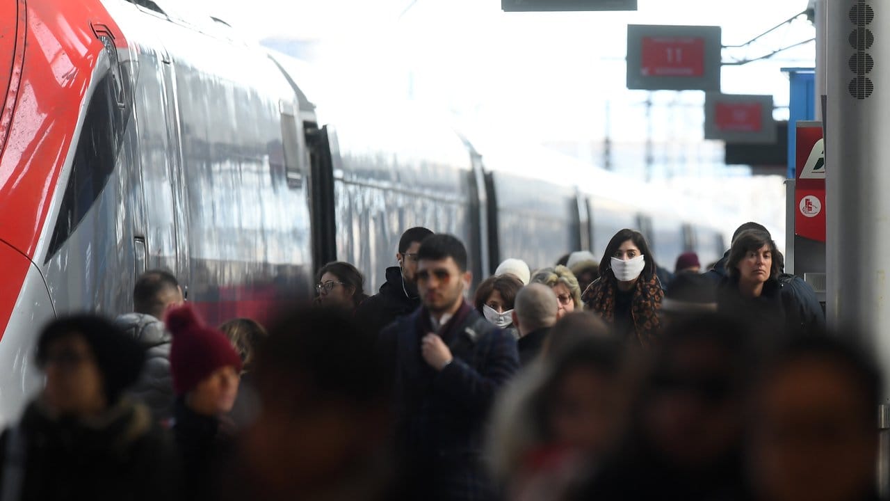 Ein Gleis am Hauptbahnhof von Mailand - einige Menschen tragen Gesichtsmasken.