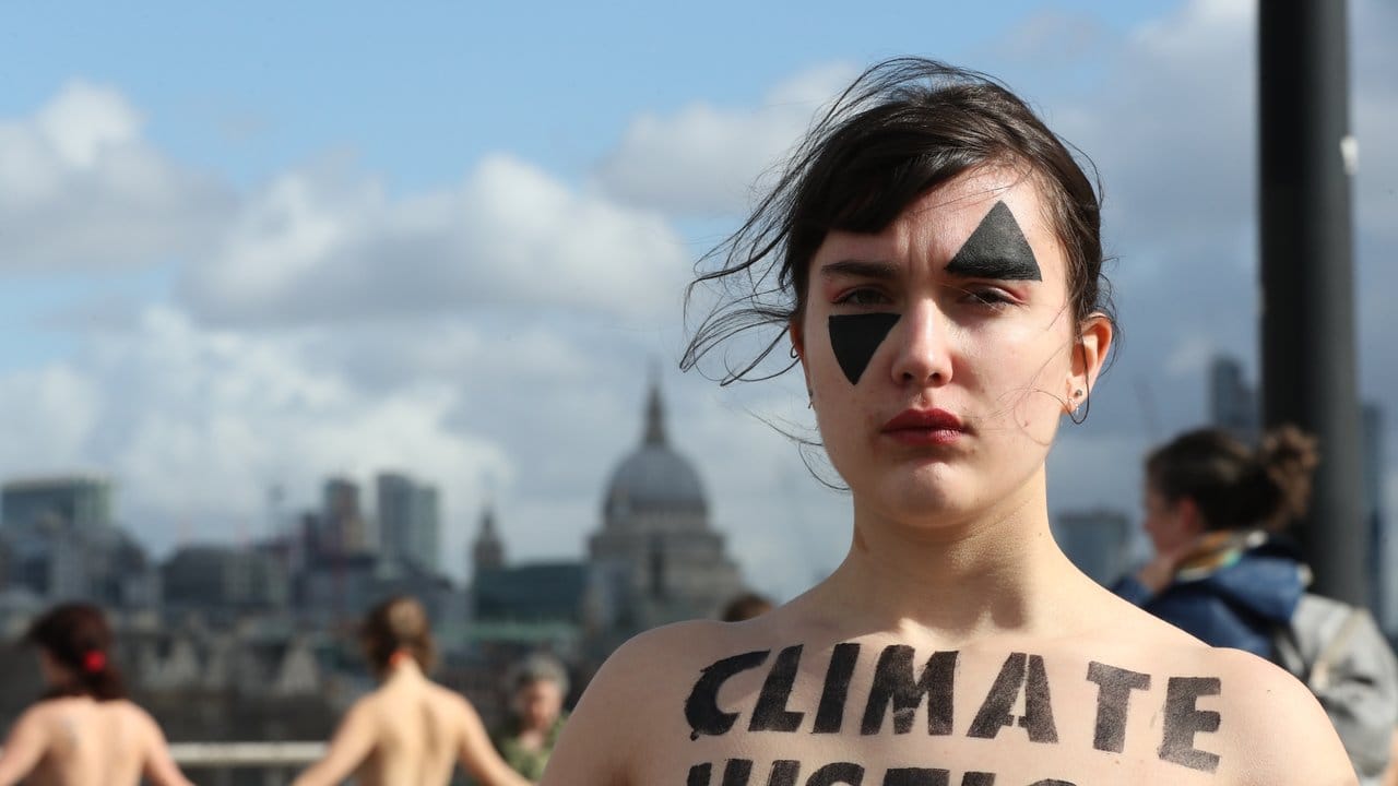 Eine Demonstrantin in London verbindet den Protest für Gleichberechtigung mit Klimaschutzforderungen.