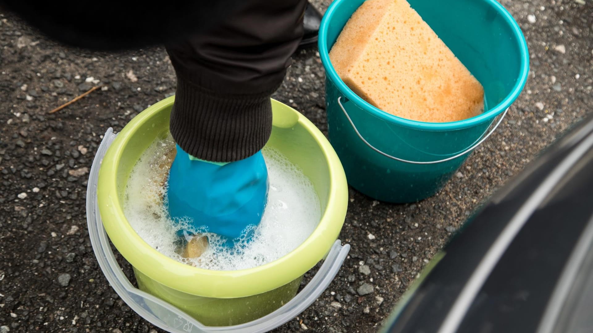 Die Zwei-Eimer-Methode: In dem einen ist ein mildes Autowasch-Shampoo und im anderen klares Wasser. Dort spülen Sie Ihre Autowasch-Werkzeuge aus, wringen sie danach aus, um frisches Shampoo-Wasser aufzunehmen. Sonst bleibt der Dreck im Schaum und im Schwamm, so dass er später Kratzer auf dem Lack erzeugt.