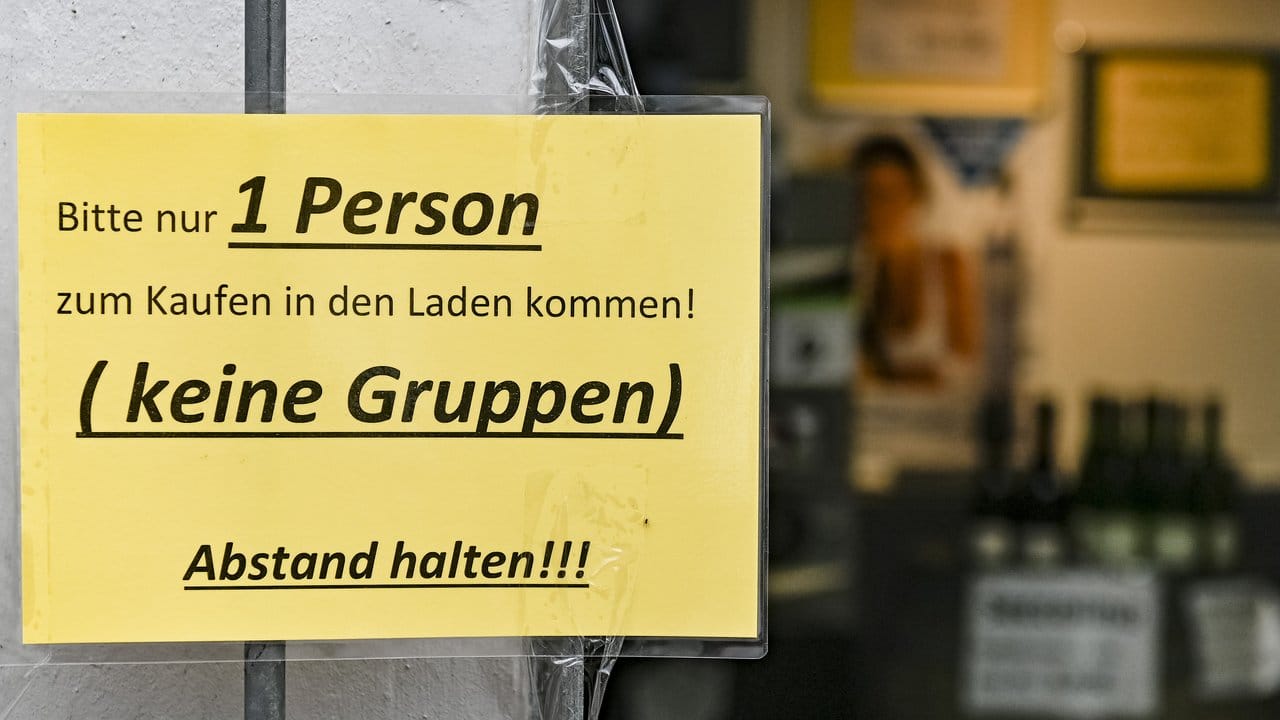 Ein Schild regelt den Einlass in ein Geschäft in Hamburg.