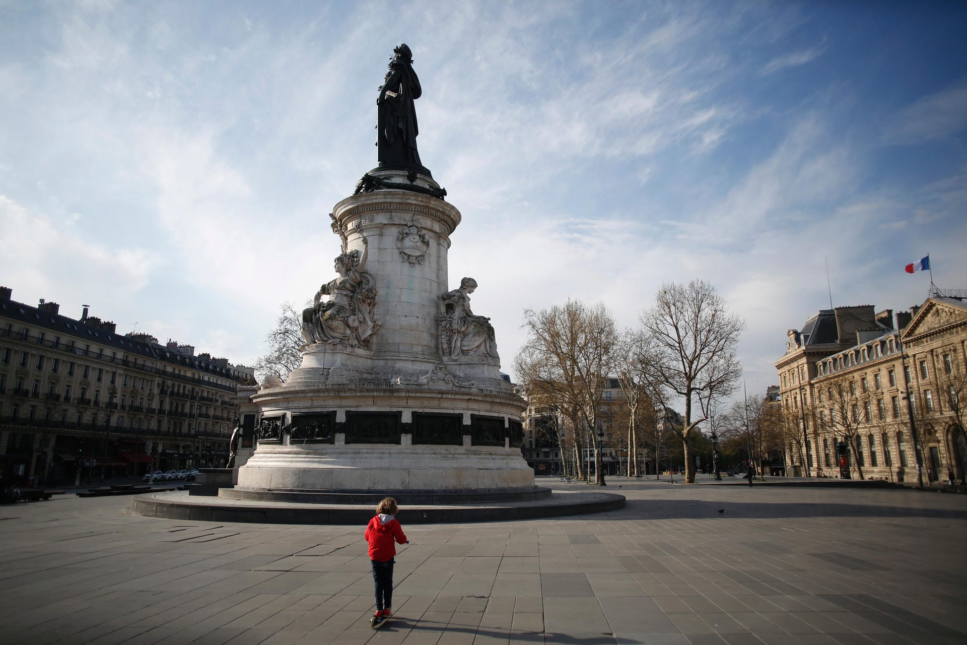 Frankreich, Paris: Ein Kind fährt mit einem Roller auf dem son menschenleeren Platz der Republik.