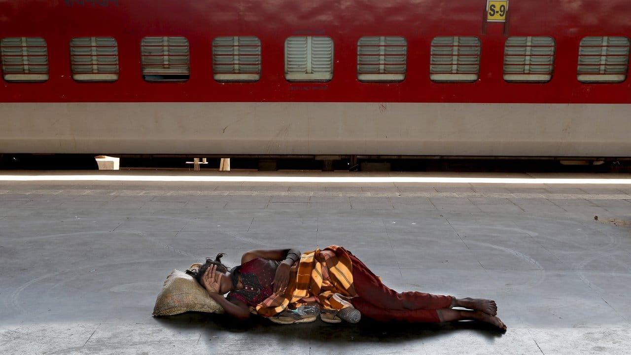 Eine obdachlose Frau schläft auf einem aufgrund der Corona-Pandemie leeren Bahnsteig in einem Vorort von Mumbai.