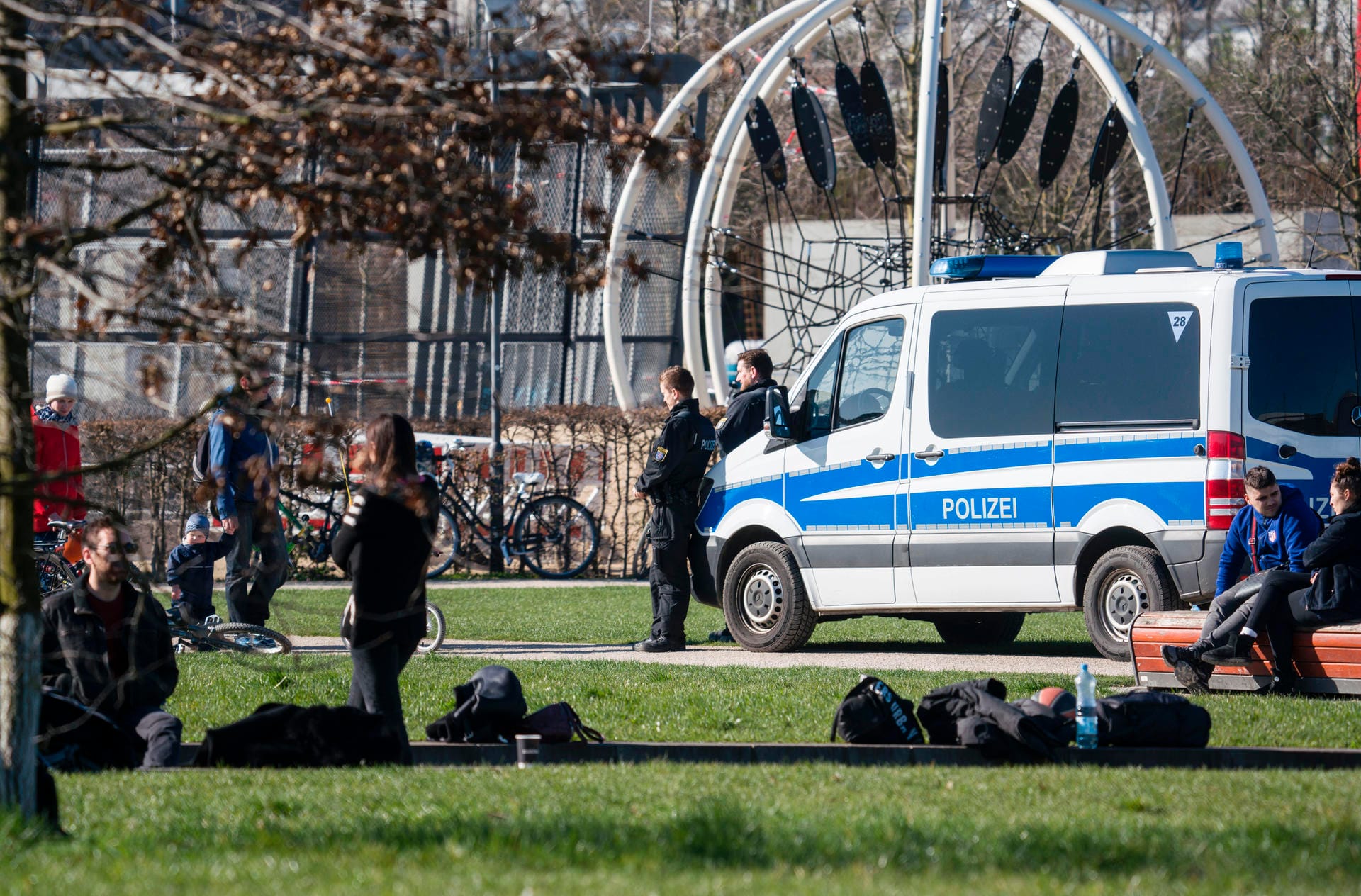 Polizisten stehen in der Freizeit- und Sportanlage Hafenpark: Sie kontrollieren, ob gegen die Versammlungsbestimmungen verstoßen wird.