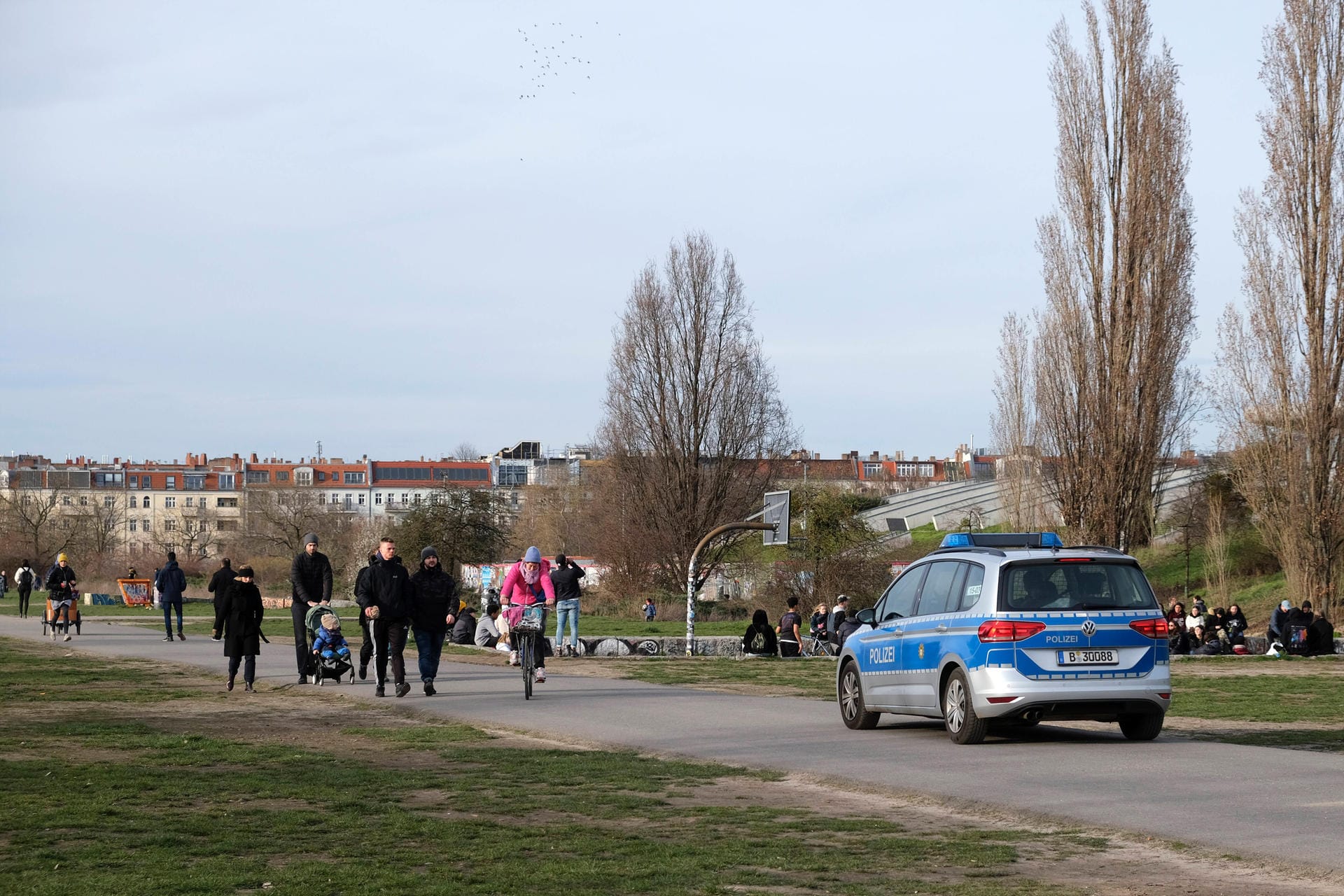 Ein Streifenwagen fährt durch den Berliner Mauerpark: In regelmäßigen Abständen kontrollieren die Beamten den Park auf einen möglichen Verstoß gegen die Corona-Maßnahmen.