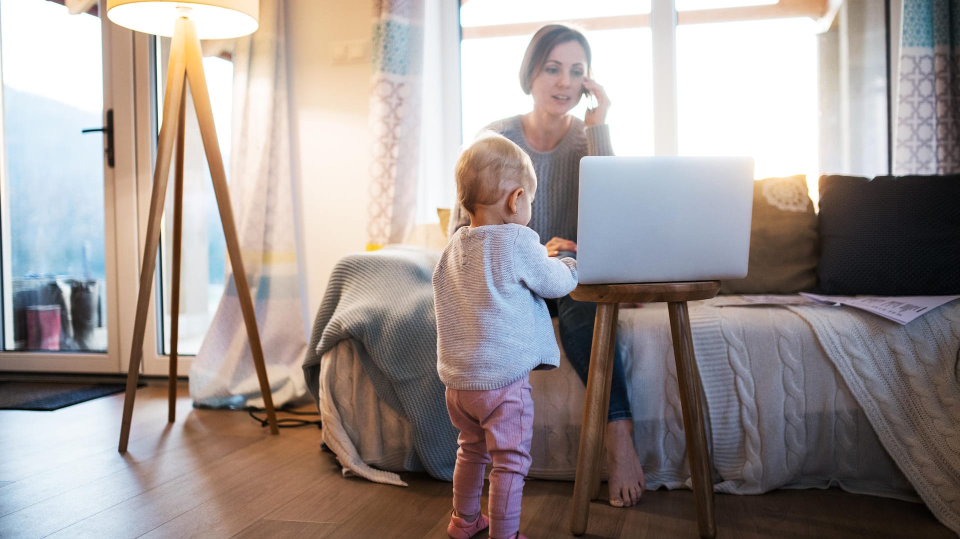 Eine junge Mutter mit ihrer Tochter im Home Office während der Corona-Zeit.