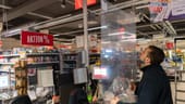 Dresden: Im Kampf gegen die Ausbreitung des neuartigen Coronavirus installiert ein Mitarbeiter in einem Supermarkt eine Plexiglasscheibe an der Kasse.