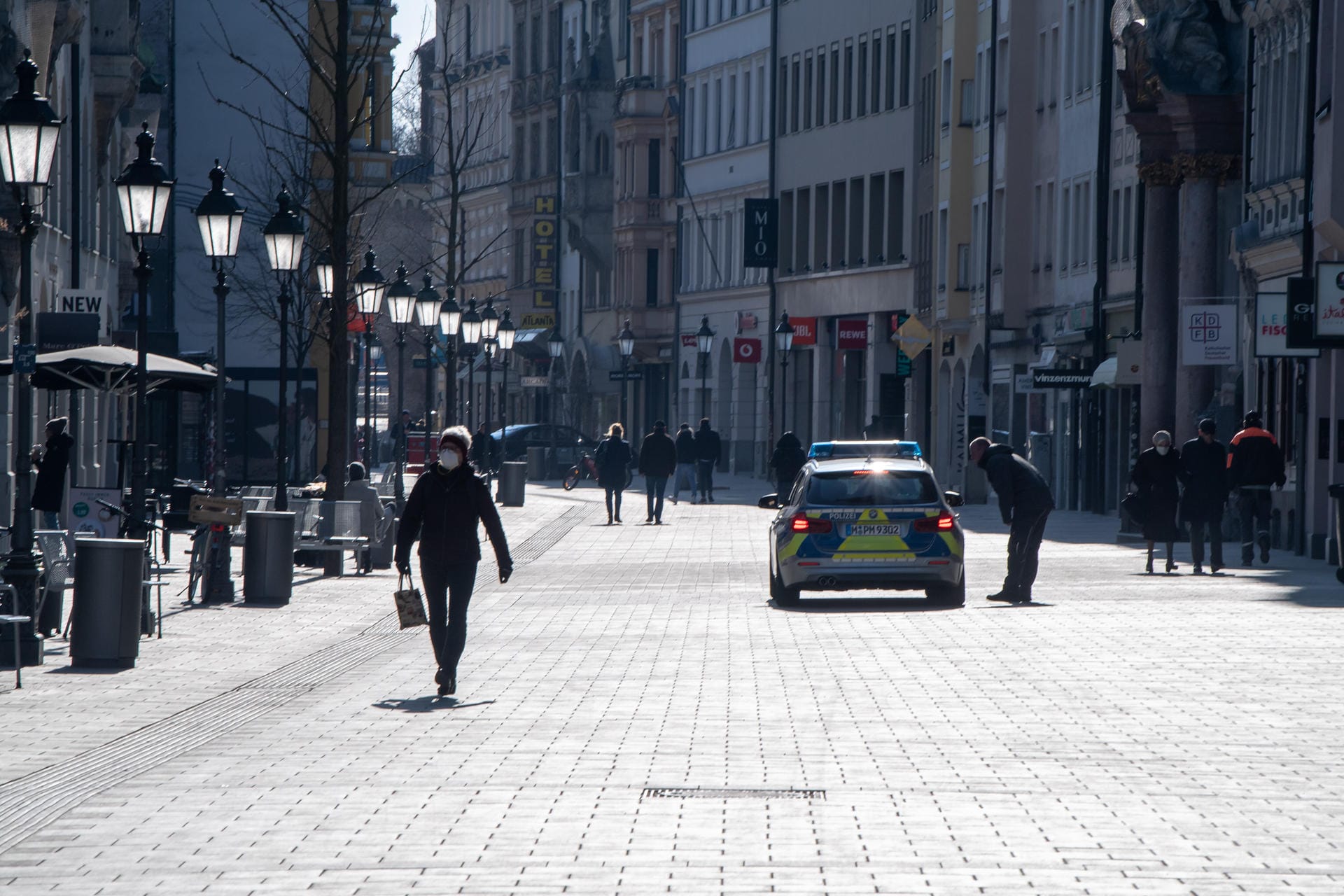Münchner Innenstadt: Ein Streifenwagen fährt durch die Fußgängerzone, die Straße ist fast menschenleer.