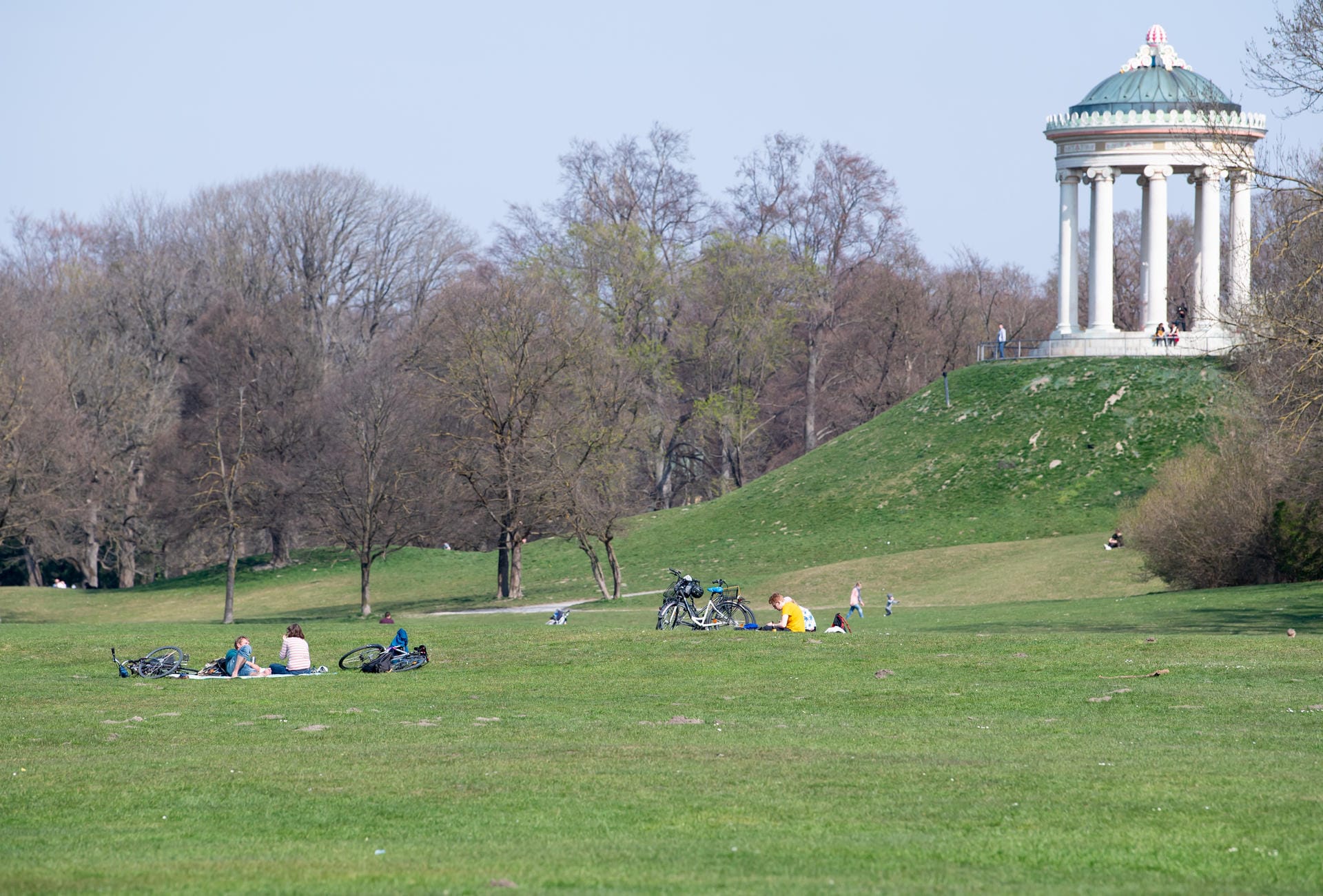 Englischer Garten: Nur wenige Menschen sitzen in der Parkanlage, um das Wetter zu genießen.