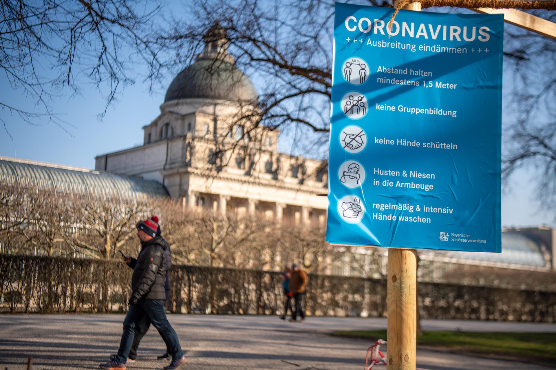 Hofgarten der Staatskanzlei: Hier hängt ein blaues Schild mit Verhaltsregeln zur Eindämmung des Coronavirus.