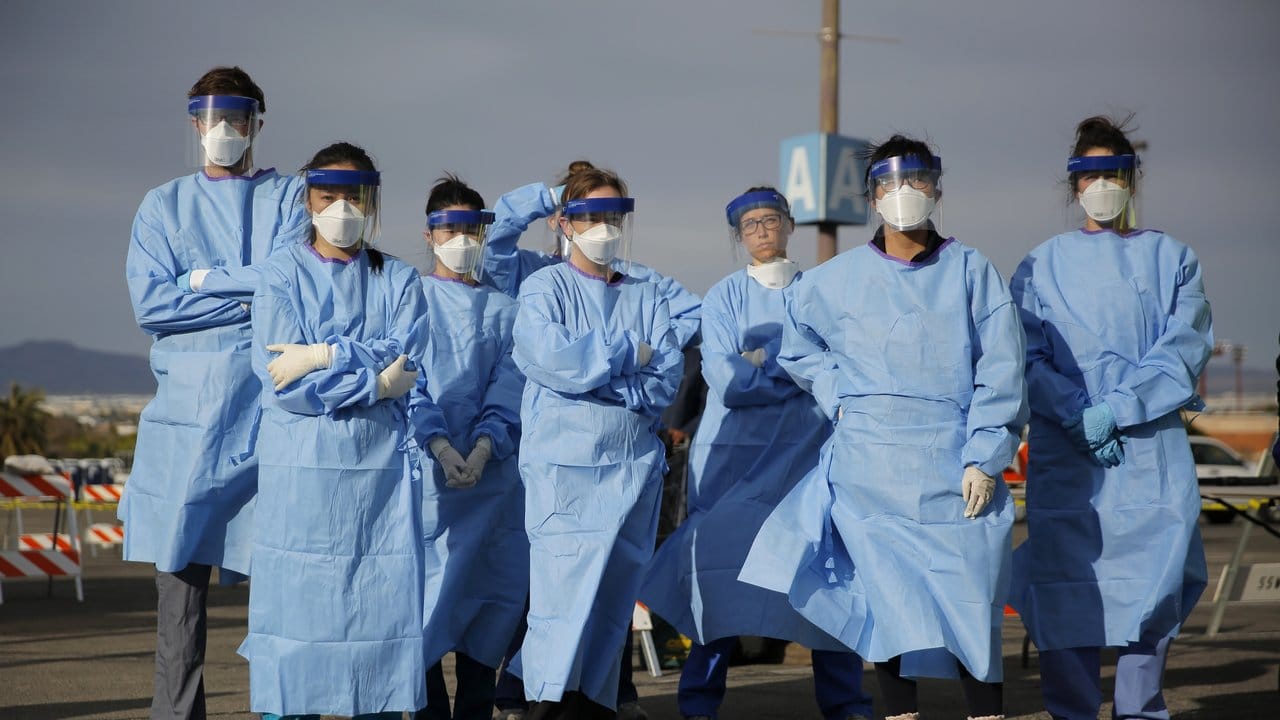 Medizinstudenten und Arzthelferinnen in Schutzkleidung stehen zusammen, bevor sie in einem Camp in Las Vegas Obdachlose auf eine mögliche Infizierung testen.
