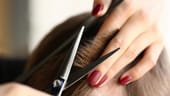 Haareschneiden mit Schere: Indem Sie einzelne Haarsträhnen zwischen Zeige- und Mittelfinger klemmen und mit beiden Fingern den Kopf berühren, können Sie einen gleichmäßigen Abstand halten und die richtige Länge treffen.