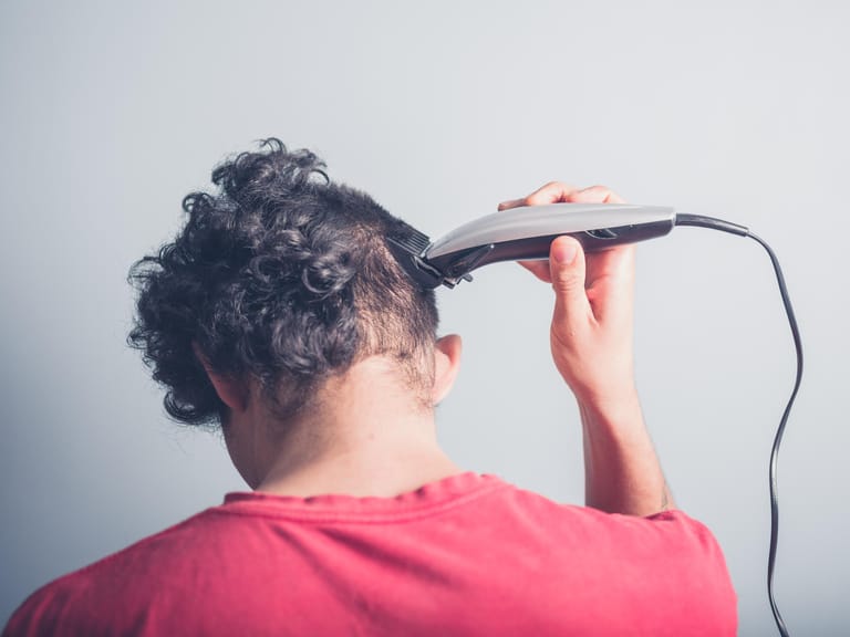 Schnitt mit der Haarschneidemaschine: Sie sollten mit dem Aufsatz des Haarschneiders auf der Kopfhaut entlang fahren, damit alle Haare gleichmäßig gekürzt werden.