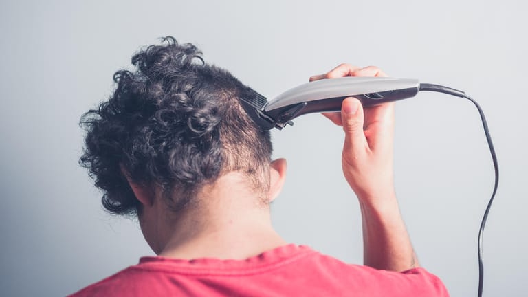 Schnitt mit der Haarschneidemaschine: Sie sollten mit dem Aufsatz des Haarschneiders auf der Kopfhaut entlang fahren, damit alle Haare gleichmäßig gekürzt werden.