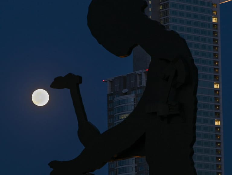 Frankfurt/Main: Der Mond steht als sogenannter Supermond hinter dem berühmten "Hammering Man", ein Kunstwerk des US-amerikanischen Künstlers Jonathan Borofsky.