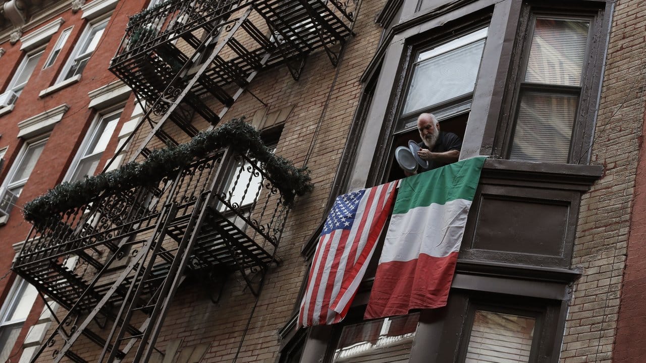 Ein Mann schlägt im New Yorker Stadtteil Little Italy Topfdeckel gegeneinander, um seine Unterstützung für die Helfer gegen die Pandemie zu zeigen. Ein Mann schlägt im New Yorker Stadtteil Little Italy Topfdeckel gegeneinander, um seine Unterstützung für die Helfer gegen die Pandemie zu zeigen.