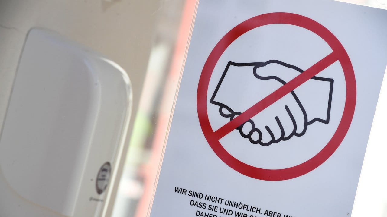 Ein Hinweisschild mit der Aufforderung, sich nicht die Hände zu schütteln, hängt an der Eingangstür des Standesamtes in Greifswald. Ein Hinweisschild mit der Aufforderung, sich nicht die Hände zu schütteln, hängt an der Eingangstür des Standesamtes in Greifswald.