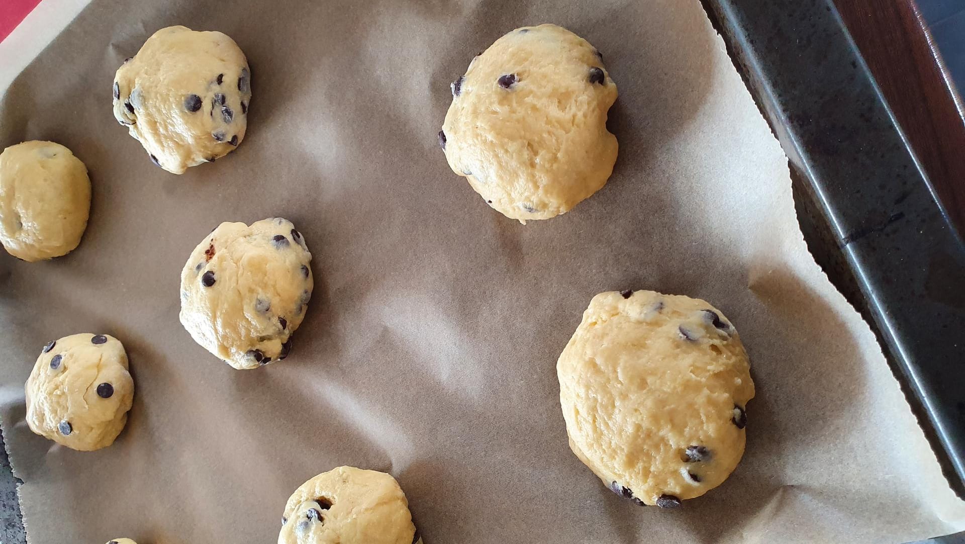 Teilen Sie den Teig in acht gleich große Kugeln auf und formen Sie daraus kleine Brötchen. Legen Sie diese mit etwas Abstand auf das Backblech.