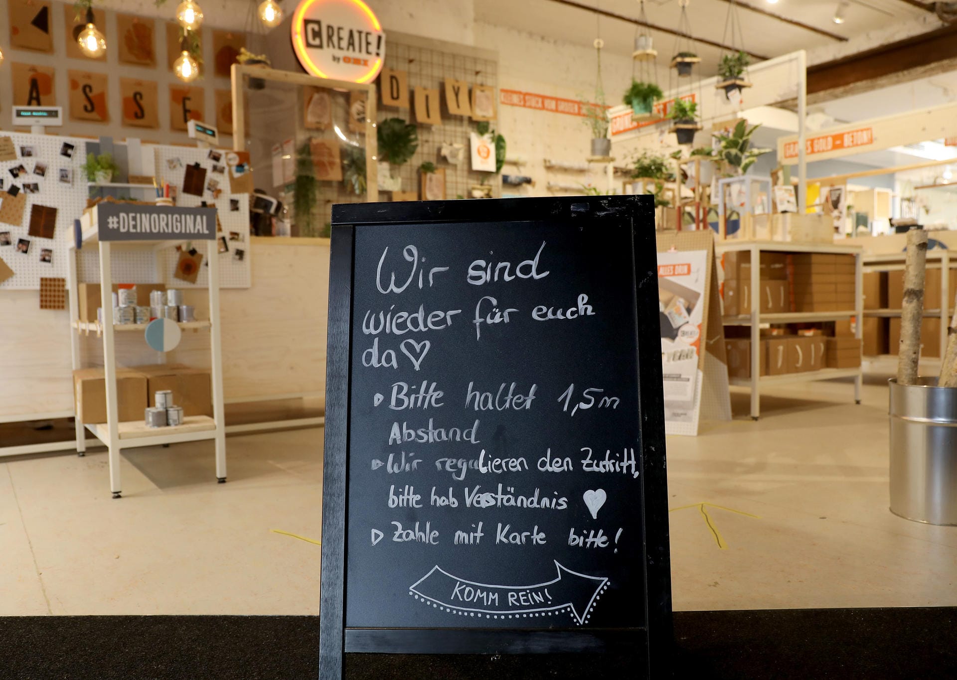 Im Eingang eines Geschäftes steht das Schild "Wir sind wieder für Euch da": Auch wenn viele Geschäfte in Köln wieder öffnen dürfen, müssen sie dafür sorgen, dass Abstandsregeln eingehalten werden. So wird etwa der Zutritt unterschiedlich reguliert.