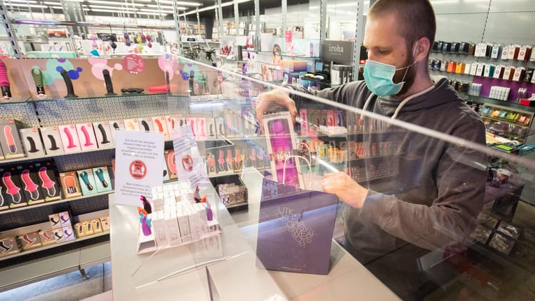 Ein Mitarbeiter mit Mundschutz steht hinter einem Plexiglasschutz an der Kasse: Auch Sexshops wie die "Boutique Bizarre" auf der Reeperbahn dürfen in Hamburg ihre Türen wieder öffnen.