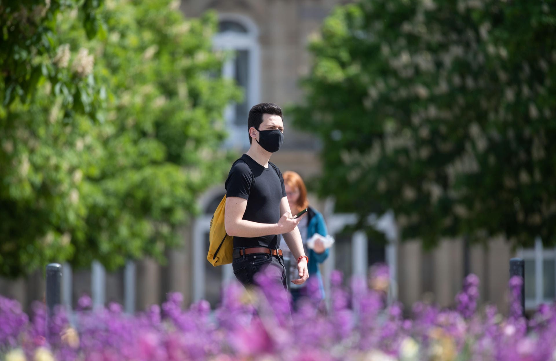 Ein Mann mit Mundschutz geht auf dem Schlossplatz in Stuttgart: Das Tragen von Schutzmasken beim Einkaufen wird bald in Baden-Württemberg für alle zur Pflicht.