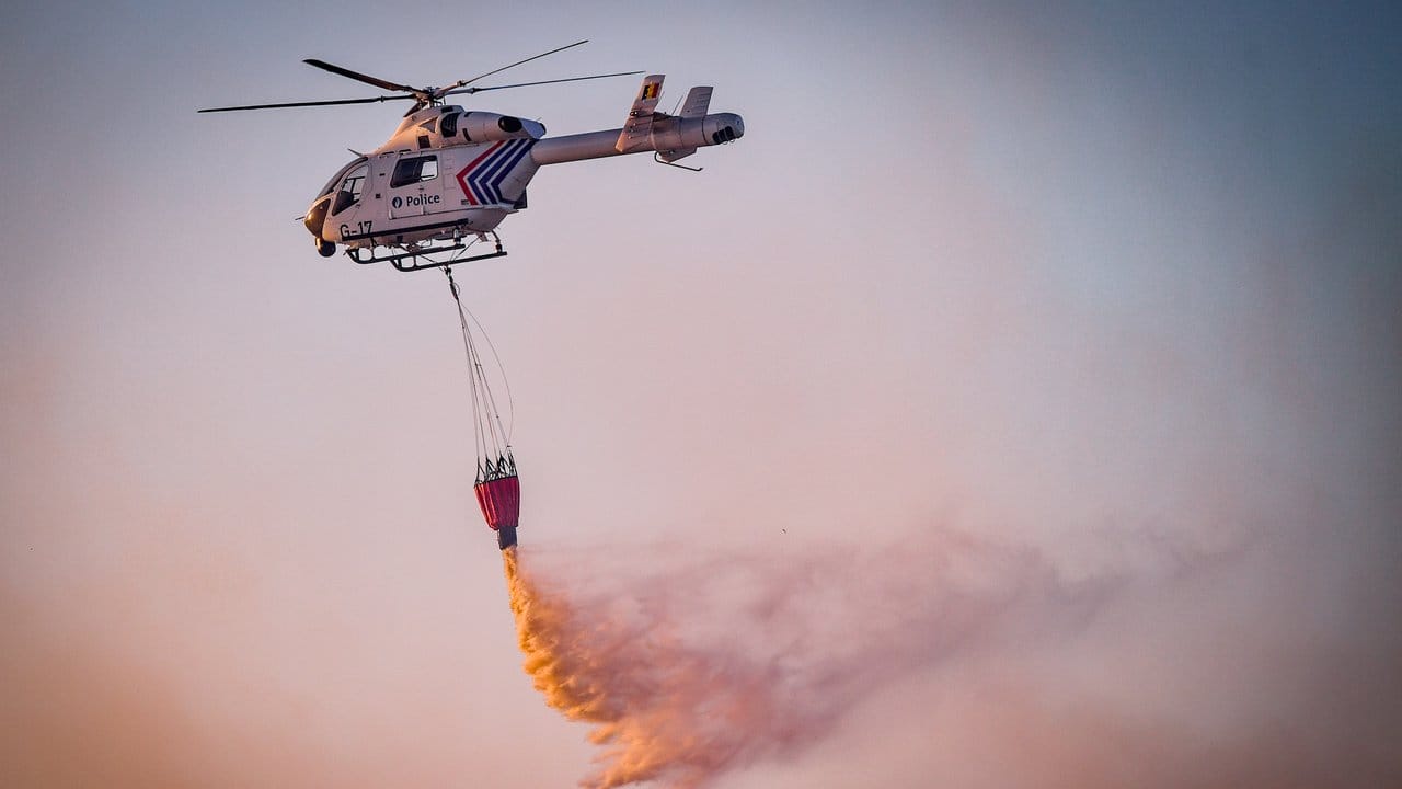 Mit Hilfe eines Hubschraubers wird aus der Luft versucht, das Feuer in dem Naturschutzgebiet "De Liereman" zu löschen.