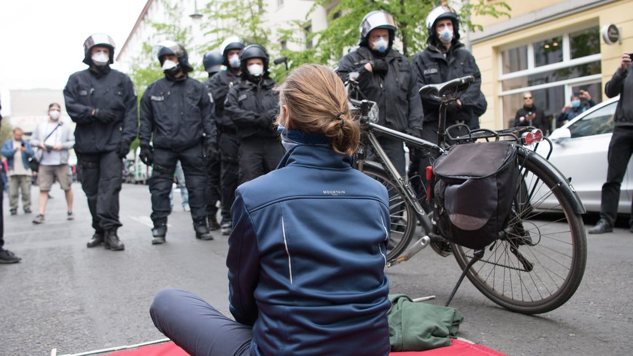 Eine Teilnehmerin sitzt bei der Kundgebung in Berlin-Mitte auf einer mitgebrachten Decke.