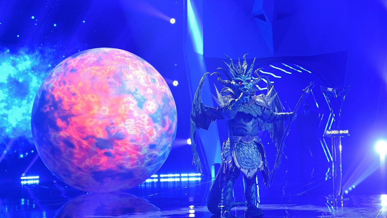Die Figur "Der Drache" steht in der Prosieben-Show "The Masked Singer" auf der Bühne. Die Figur "Der Drache" steht in der Prosieben-Show "The Masked Singer" auf der Bühne.