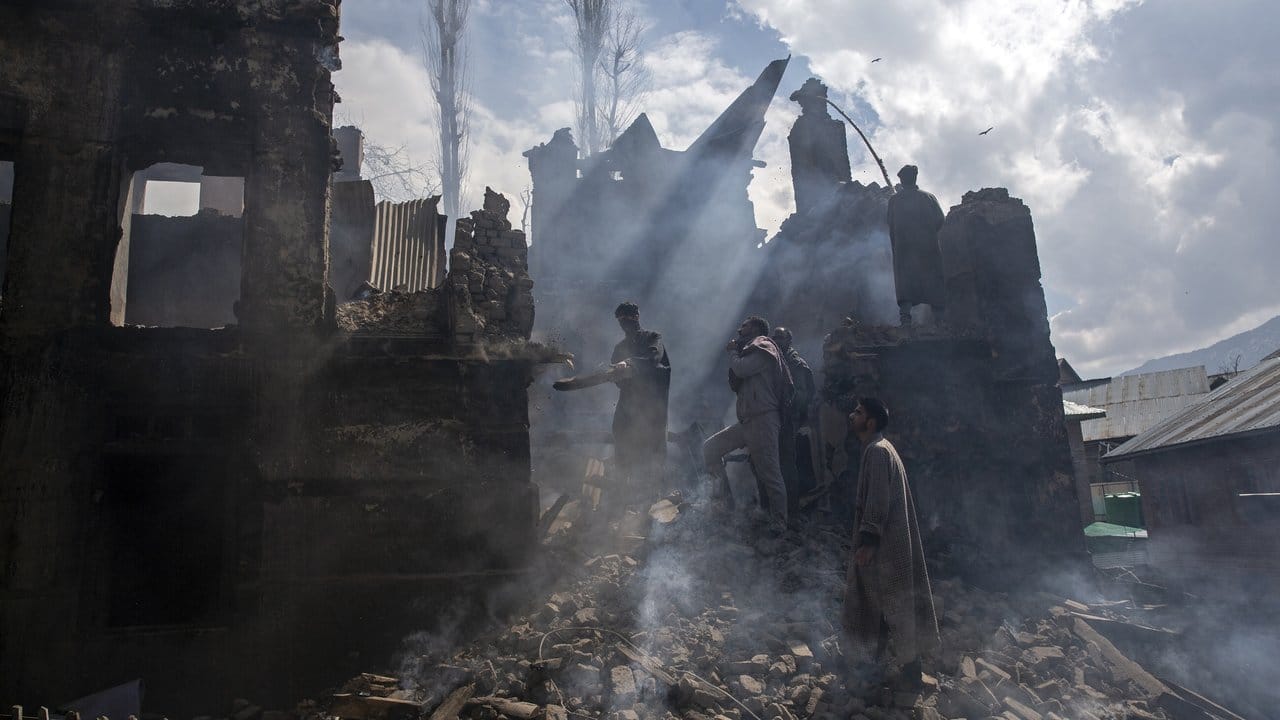 Kaschmirische Männer demontieren im Dorf Tral, südlich von Srinagar im indisch kontrollierten Kaschmir, einen Teil eines bei einem Schusswechsel zerstörten Hauses.