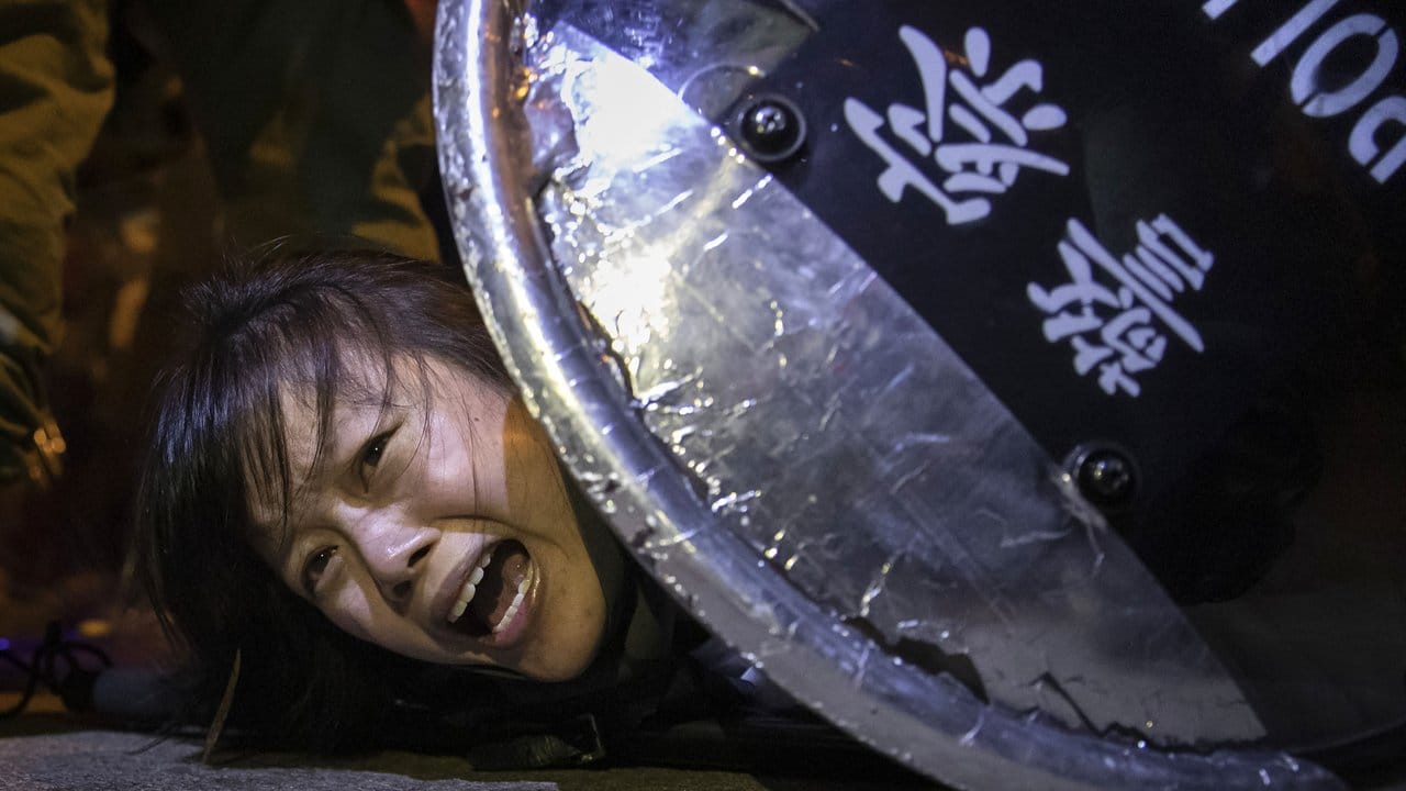 Eine Protestlerin gegen das Auslieferungsgesetz wird von der Polizei bei Auseinandersetzungen vor der Polizeistation von Mong Kok in Hong Kong festgenommen.