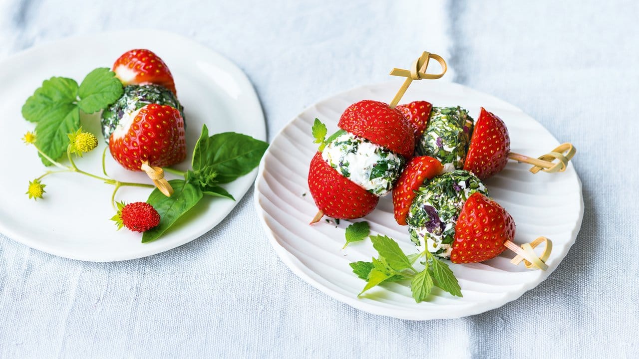 Fruchtige Spieße: Dazu steckt man Frischkäsebällchen zwischen Erdbeerhälften auf Zahnstocher.