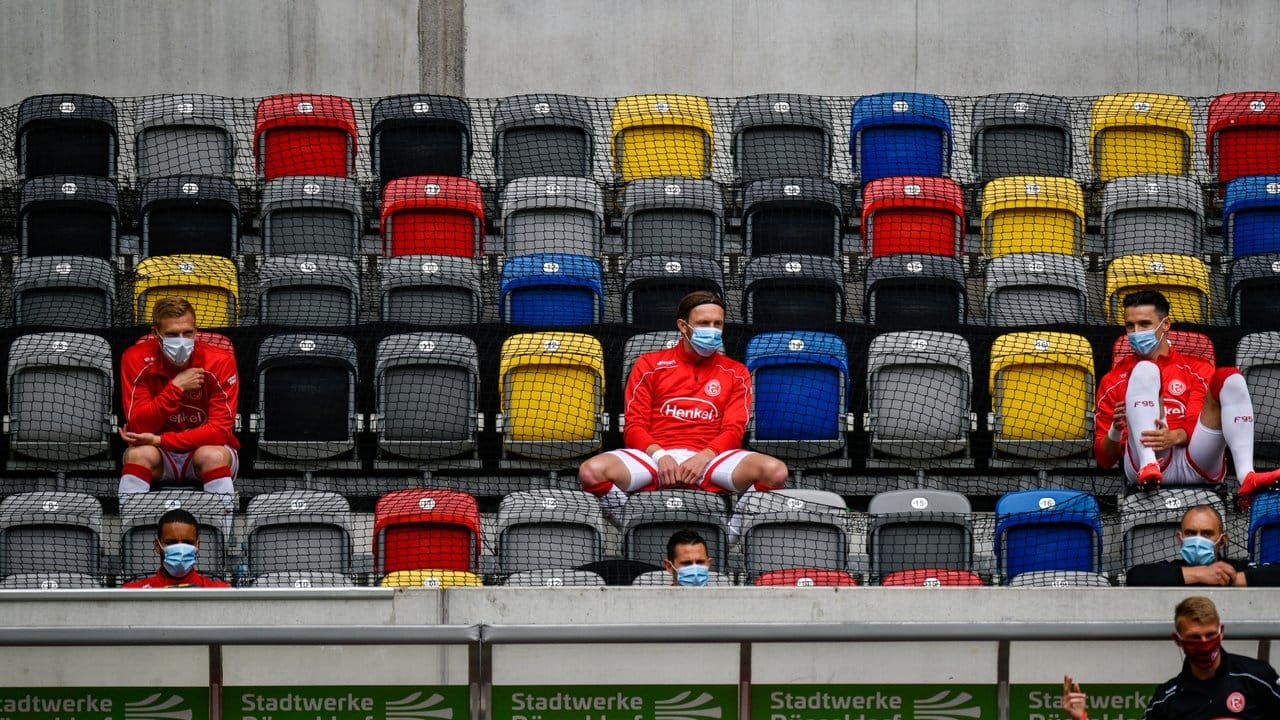 Spieler von Fortuna Düsseldorf sitzen auf der Tribüne.