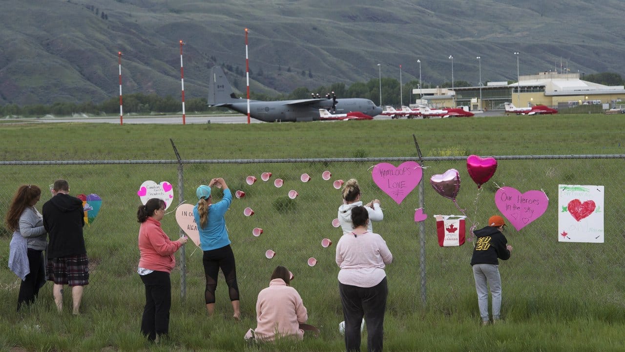 Gedenken am Zaun - im Hintergrund sind Flugzeuge der kanadischen Kunstflugstaffel "Snowbirds" zu sehen.
