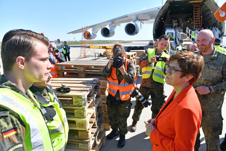 Annegret Kramp-Karrenbauer unterhält sich auf einem Flughafen mit Soldaten: Weil sie bei dem Pressetermin keine Maske trug, musste sich die Bundesverteidigungsministerin nach dem Termin entschuldigen.
