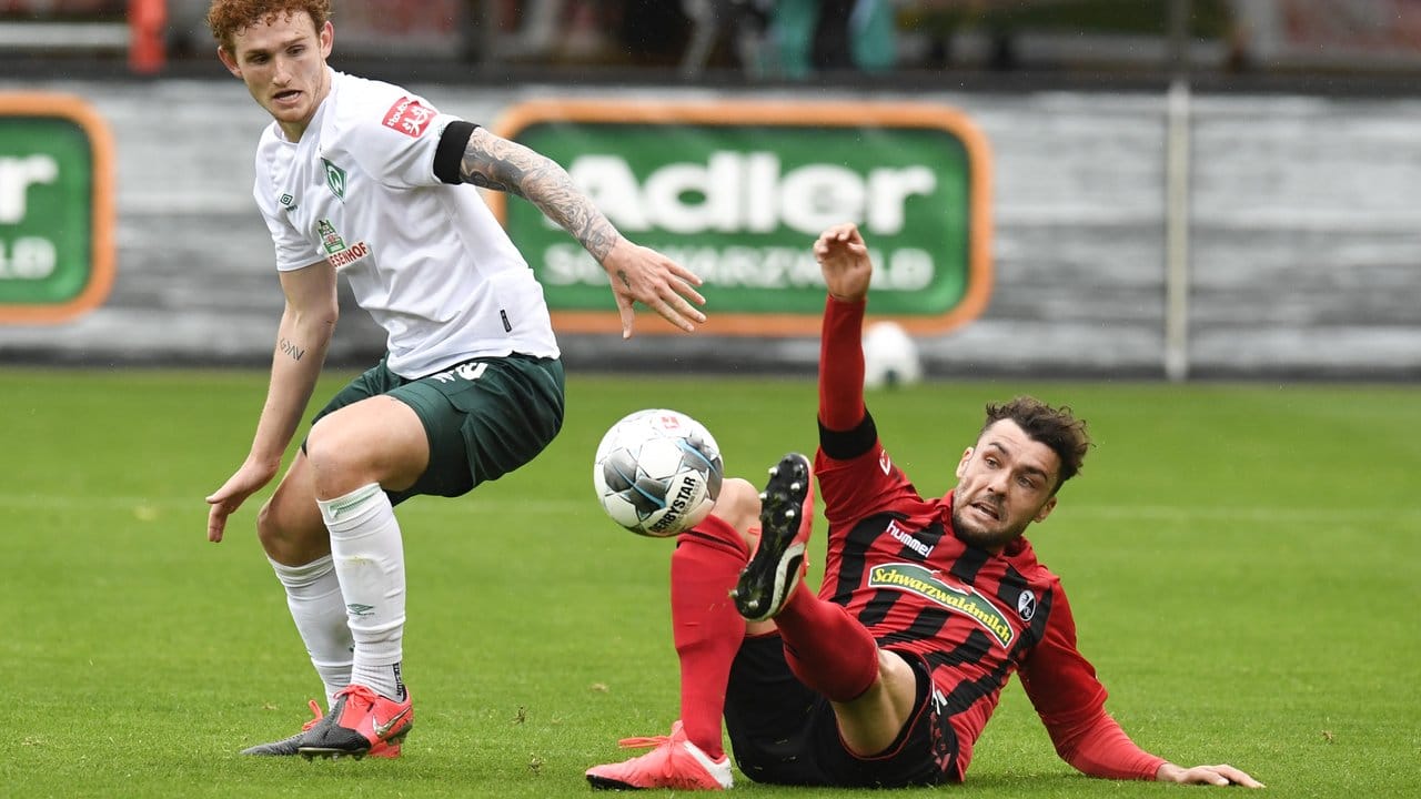 Freiburgs Manuel Gulde (r) kämpft mit Bremens Josh Sargent um den Ball.