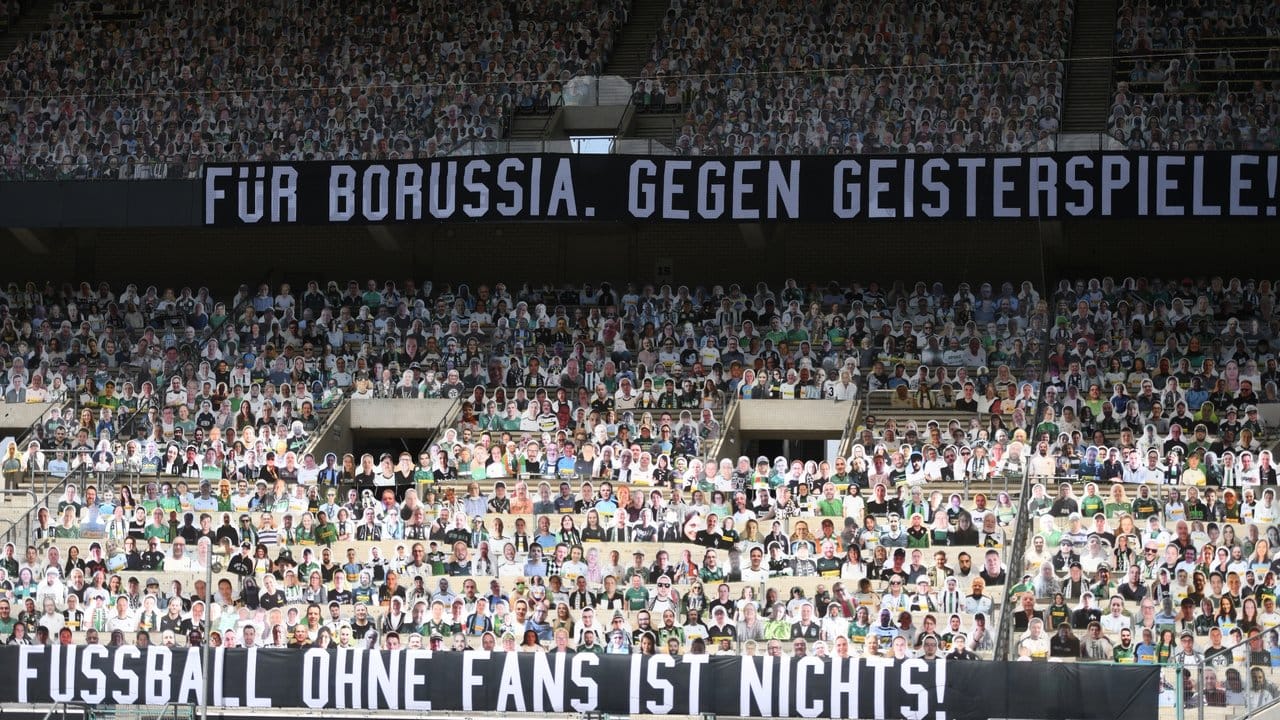 Fotos von Fans sind auf Pappfiguren auf der Tribüne des Borussia-Parks aufgestellt.
