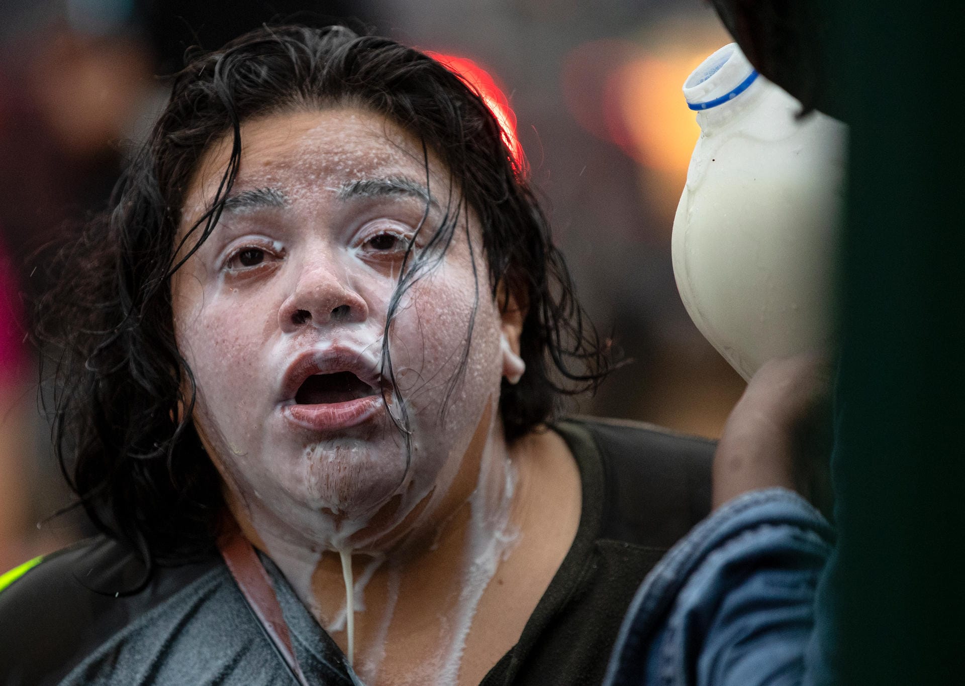 Eine Demonstrantin wird mit Flüssigkeit überschüttet.