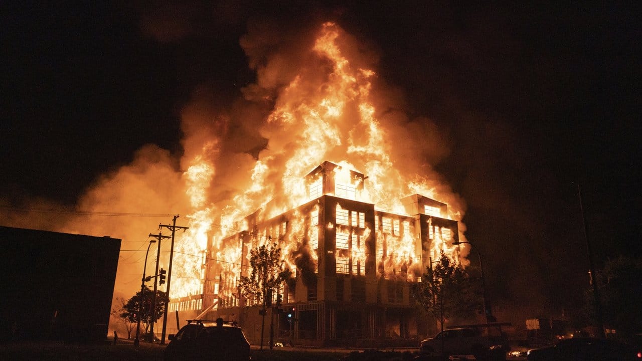 Ein mehrstöckiges Wohngebäude steht nach Protesten in Flammen.