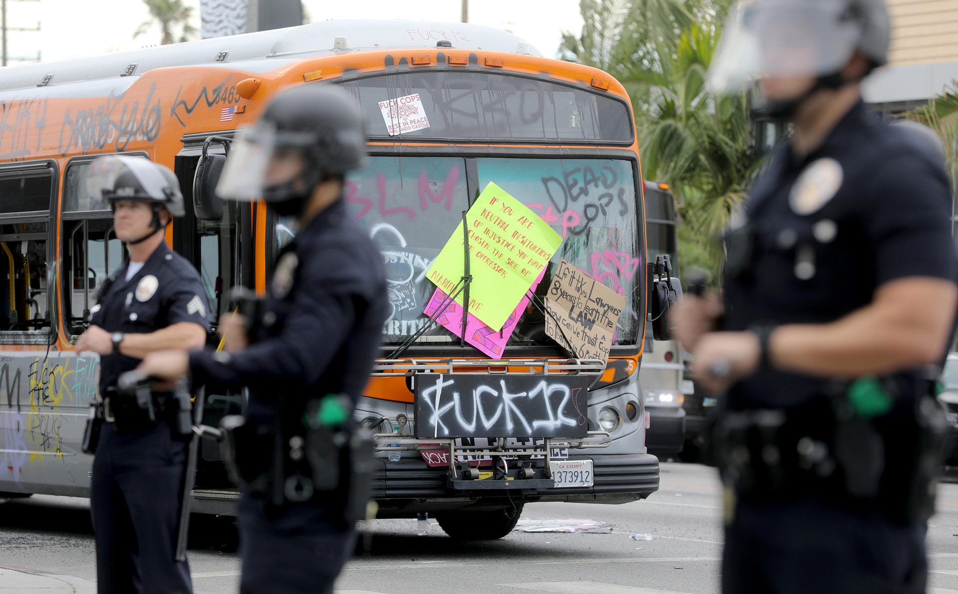 Auf einem zerstörten Bus klebt ein Plakat mit der Aufschrift: "Wenn du neutral bist in Situationen der Ungerechtigkeit, hast du dich für die Seite des Unterdrückers entschieden."