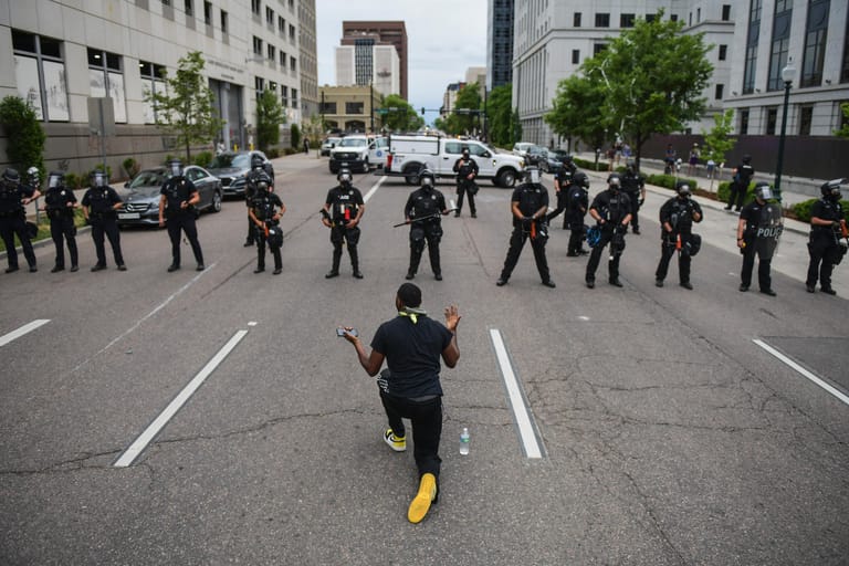 In Denver fleht ein Protestant die aufgereihten Polizisten an.