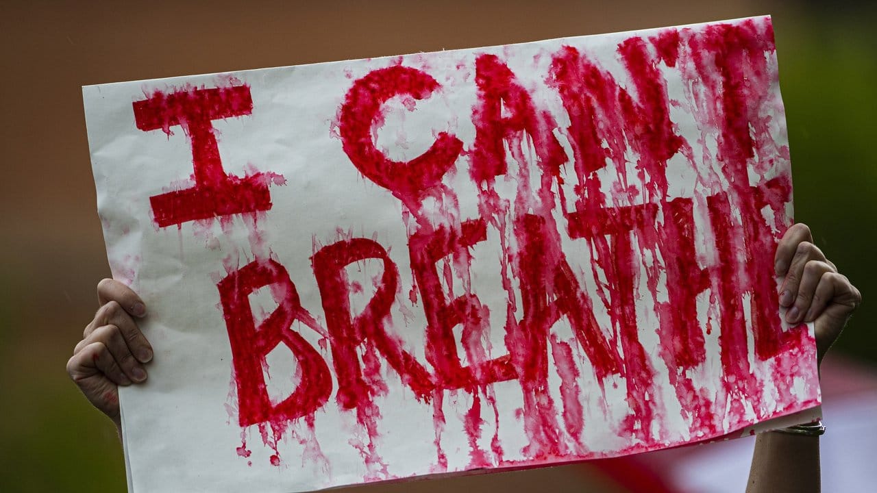 Eine Frau während einer Kundgebung mit einem Plakat auf der "I can't breathe" ("Ich kann nicht atmen") steht.