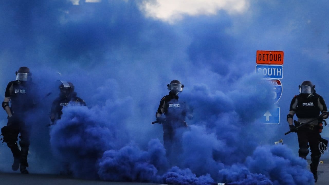 In einer blauen Rauchwolke: Polizisten in voller Montur während eines Protests in der Nähe des 5.