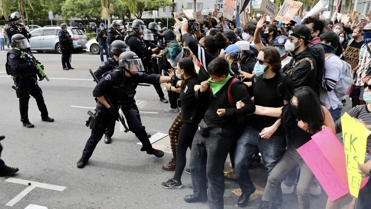 Polizeibeamte in Los Angeles versuchen, Demonstranten während eines Protestes auf einer Straße zurückzudrängen.
