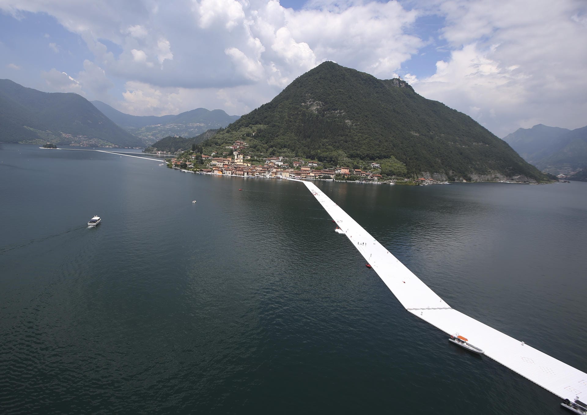 2016 installierte Christo auf dem begehbare, mit dahliengelbem Stoff bespannte schwimmende Stege.