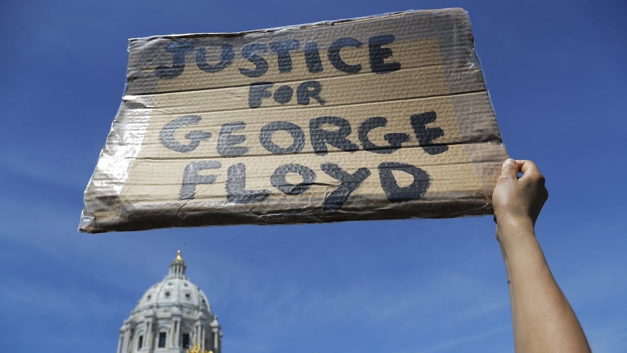 Ein Demonstrant fordert mit einem Plakat "Gerechtigkeit für George Floyd" vor dem Minnesota Statehouse.